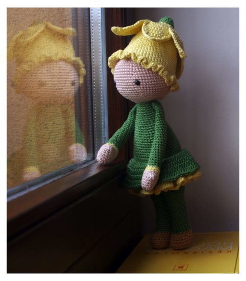 Gehäkelte Narzissenpuppe mit gelber Blüte am Fenster