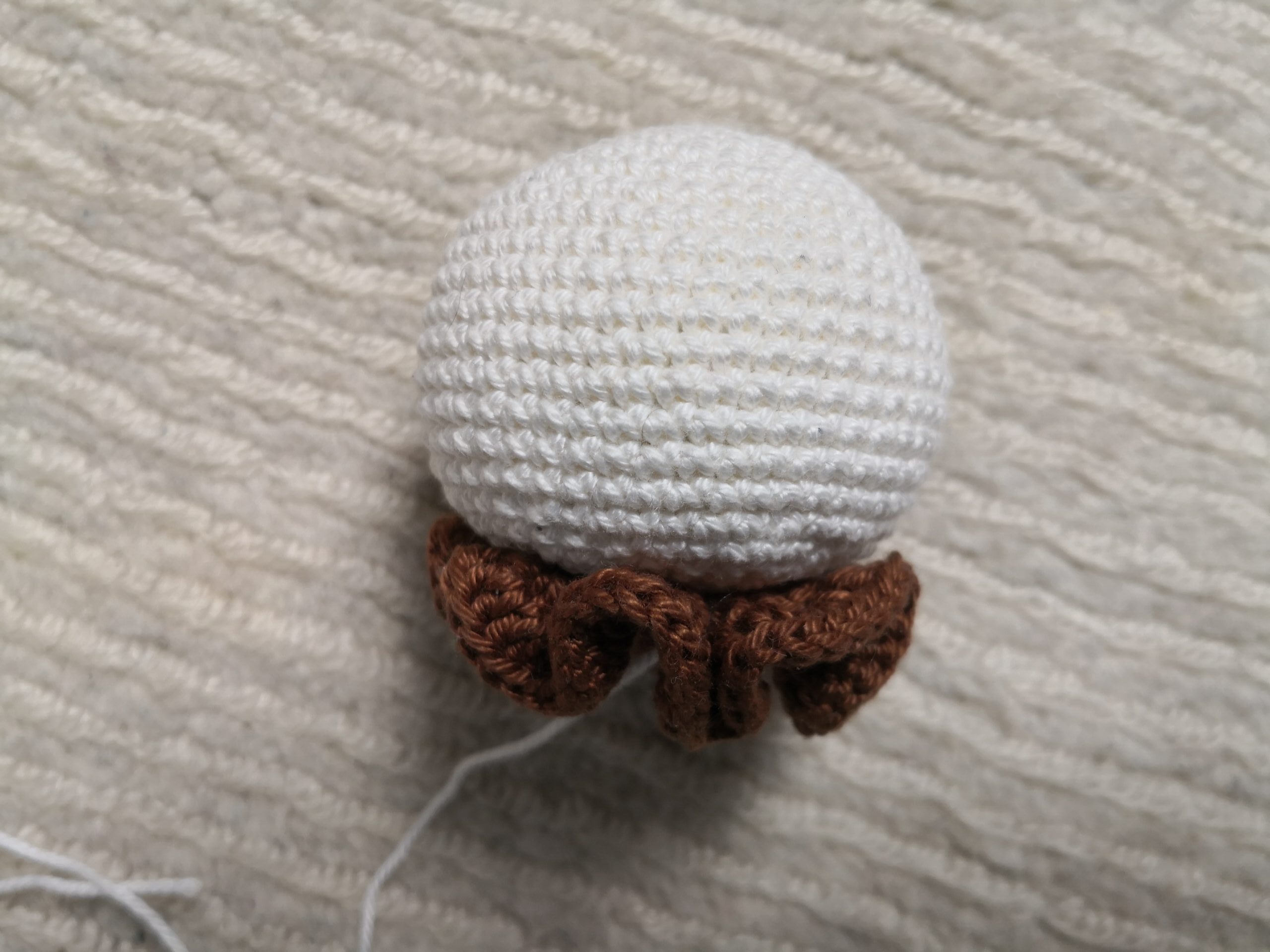 Rückansicht des gehäkelten Amigurumi Hasen-Greiflings mit braunem Häkelkragen