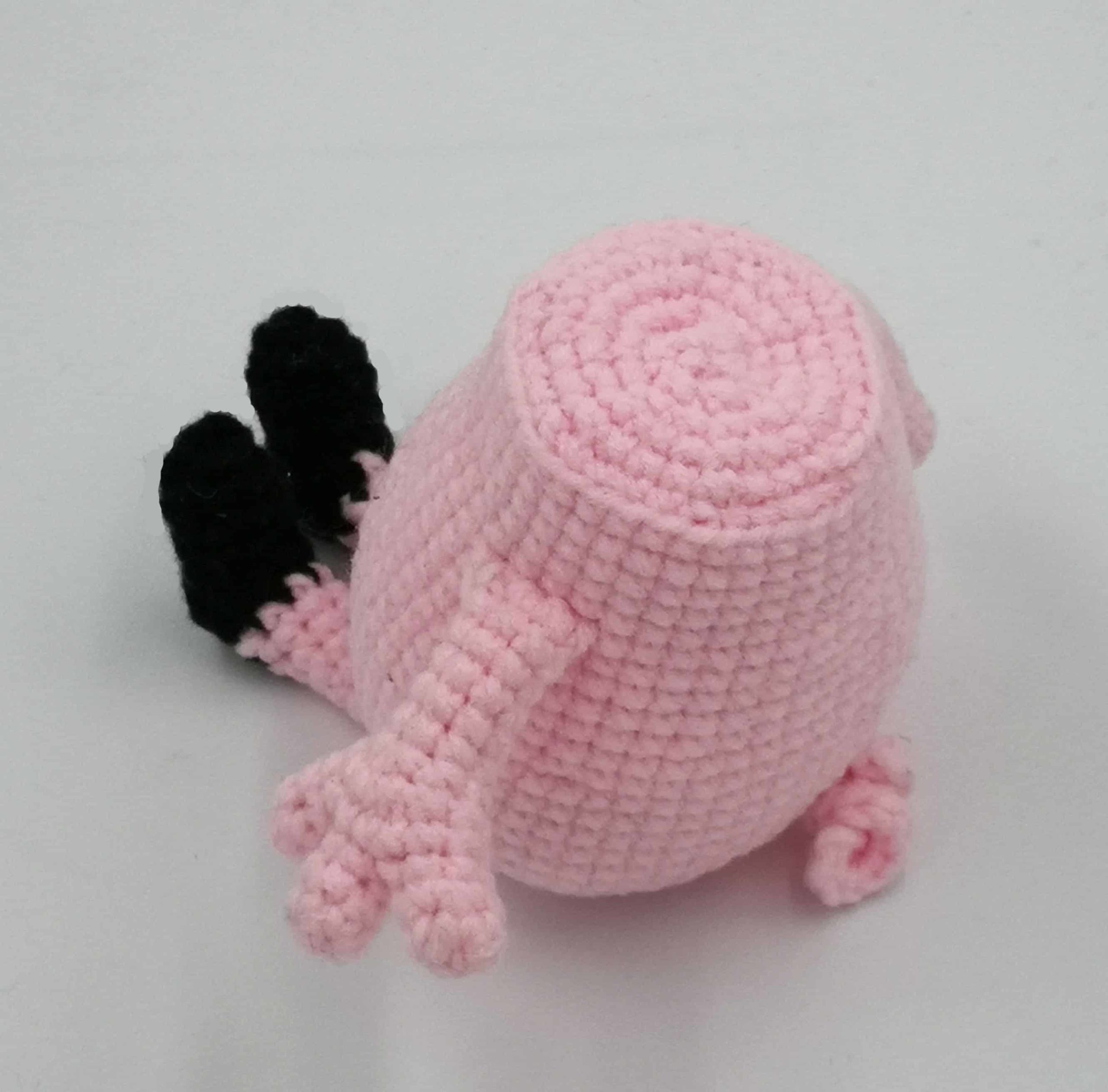 Rückansicht der gehäkelten Peppa-Wutz-Figur mit angenähter Schwanzspirale – Körper fast fertig