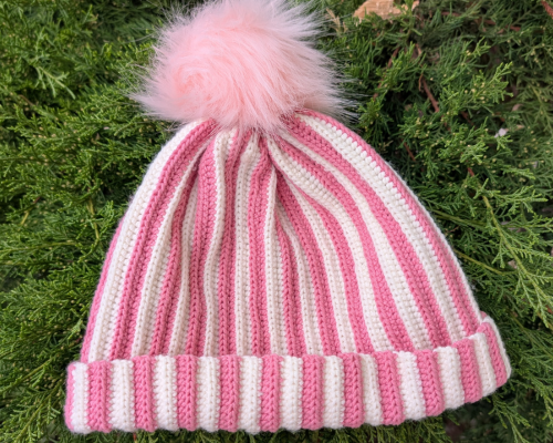 Gehäkelte Mütze mit Rippenmuster in Rosa-Weiß mit Bommel